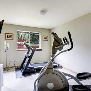 Bright gym room with exercise equipments and tv